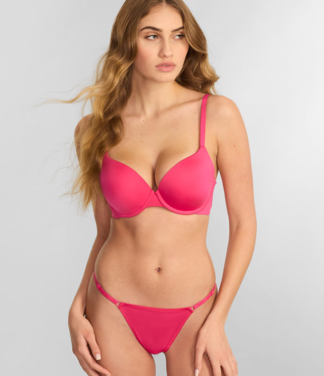 woman standing in bright pink thong and bra